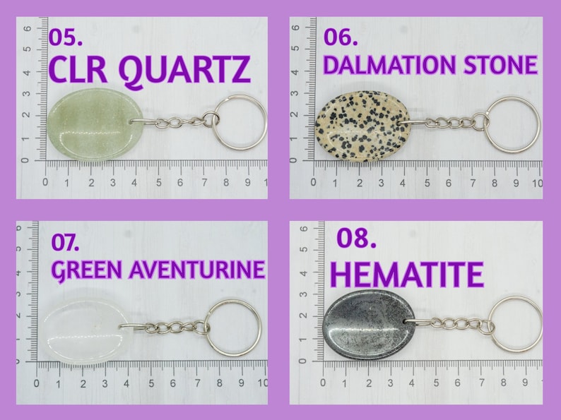 Op de afbeelding: Vier verschillende soorten stenen aan sleutelhangers. De stenen zijn gelabeld met "CLR QUARTZ", "DALMATION STONE", "GREEN AVENTURINE" en "HEMATITE".