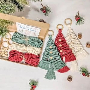 May include: A craft kit for making three macrame Christmas tree ornaments. The kit includes three wooden rings, three balls of yarn in red, white, and green, and wooden beads. The kit also includes instructions for making the ornaments.
