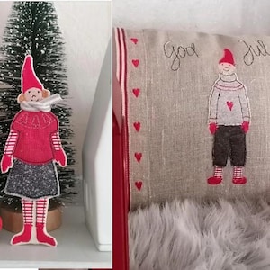 Könnte beinhalten: Ein rotes und weißes Weihnachts-Gnom-Ornament mit roter Mütze, weißem Schal und rotem Pullover. Der Gnom steht vor einem kleinen künstlichen Weihnachtsbaum. Der Gnom hält eine rot-weiß gestreifte Tasche.