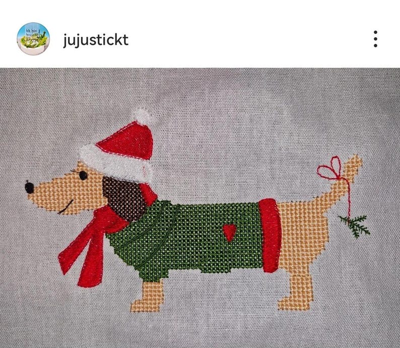 May include: Cross-stitch pattern of a dachshund wearing a green sweater, red scarf, and a Santa hat. The dog is holding a sprig of holly in its mouth.