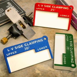 May include: A white ceramic mug with a black handle and the text "But First, Coffee" in a black, handwritten-style font. The mug is on a white surface.