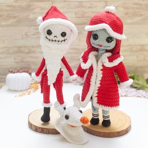Op de afbeelding: Gehaakte figuren van Jack Skellington als kerstman en Sally uit The Nightmare Before Christmas, met Zero de spookhond. De figuren dragen rood-witte outfits en staan op houten schijfjes. Er is ook een gehaakte pompoen aanwezig.