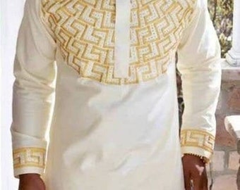 May include: A white long-sleeved shirt with a gold geometric pattern on the front and cuffs. The shirt has a mandarin collar and a button closure.