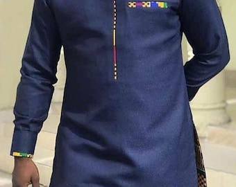 Può includere: Una camicia a maniche lunghe blu navy con un bordo colorato sul davanti e una piccola tasca sul petto. La camicia ha un colletto alla coreana e una vestibilità rilassata.