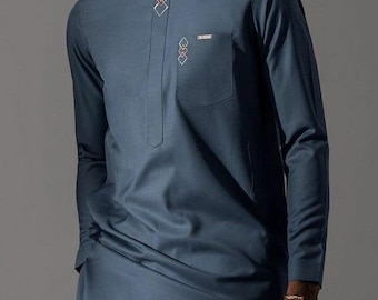 May include: A man wearing a dark blue long-sleeved shirt with a geometric design on the collar and a small pocket on the chest. The shirt is tucked into matching dark blue trousers. The man is standing in front of a grey background. The text "REAZZ WEARS" is visible at the bottom of the image.