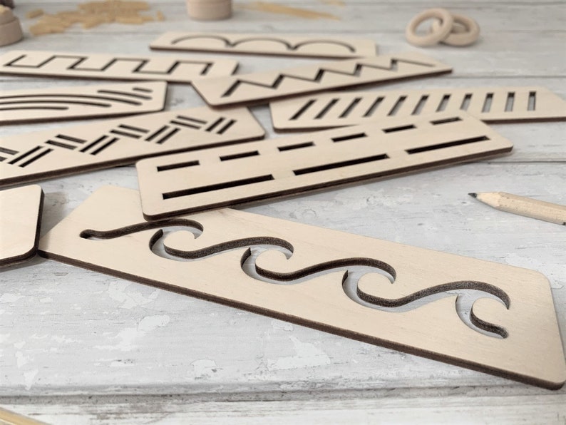 May include: A set of wooden stencils featuring a variety of patterns, such as waves, zigzags, and lines. The stencils are crafted from light brown wood and have a smooth finish.
