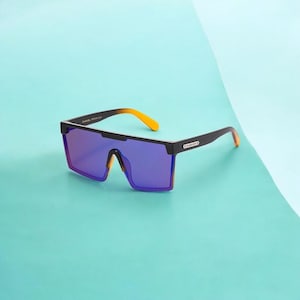 May include: Black sunglasses with a wide, rectangular frame and purple lenses. The arms transition from black to orange at the tips. The sunglasses are set against a light blue and teal background.