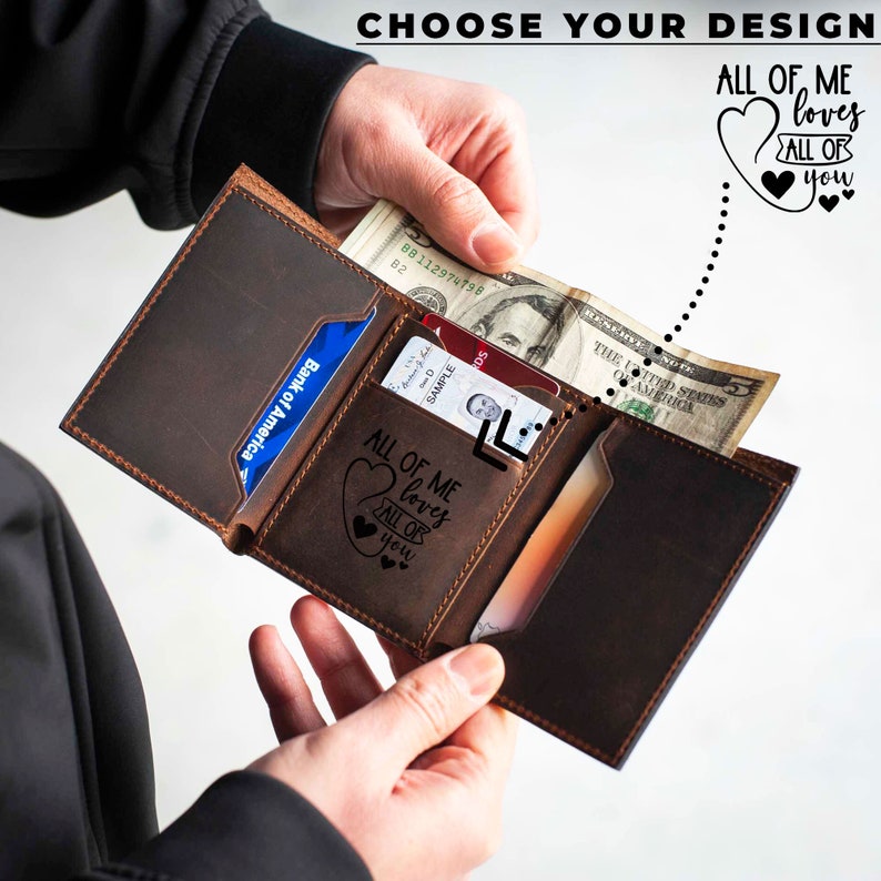 May include: A brown leather wallet with a card slot and a billfold. The wallet has a personalized inscription that reads "All of me loves all of you".