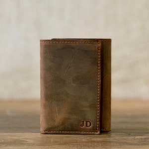 May include: A brown leather wallet with the initials "JD" embossed on the front.