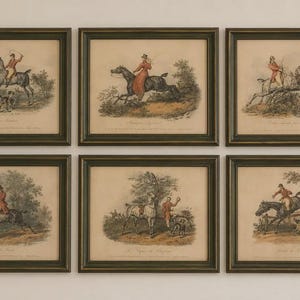 May include: A set of six framed prints featuring equestrian scenes with riders in red coats, horses, and hunting dogs. Each print is enclosed in a dark, textured frame with a cream-colored mat, depicting various outdoor hunting activities.