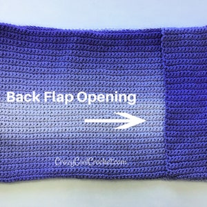 Op de afbeelding: Een handgemaakt gehaakt item in paarse tinten, met een opening aan de achterflap. De tekst "Back Flap Opening" en een pijl zijn zichtbaar. Het item is waarschijnlijk een sjaal of omslagdoek.