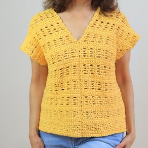 May include: A yellow crochet top with a V-neck and short sleeves. The top has a delicate openwork pattern.