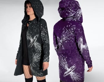 Puede incluir: Dos chaquetas con capucha, una negra y otra morada, con un diseño único. La chaqueta negra presenta un estampado gráfico blanco y un patrón de panal en la capucha. La chaqueta morada tiene un diseño similar con un estampado gráfico blanco y un patrón de panal.