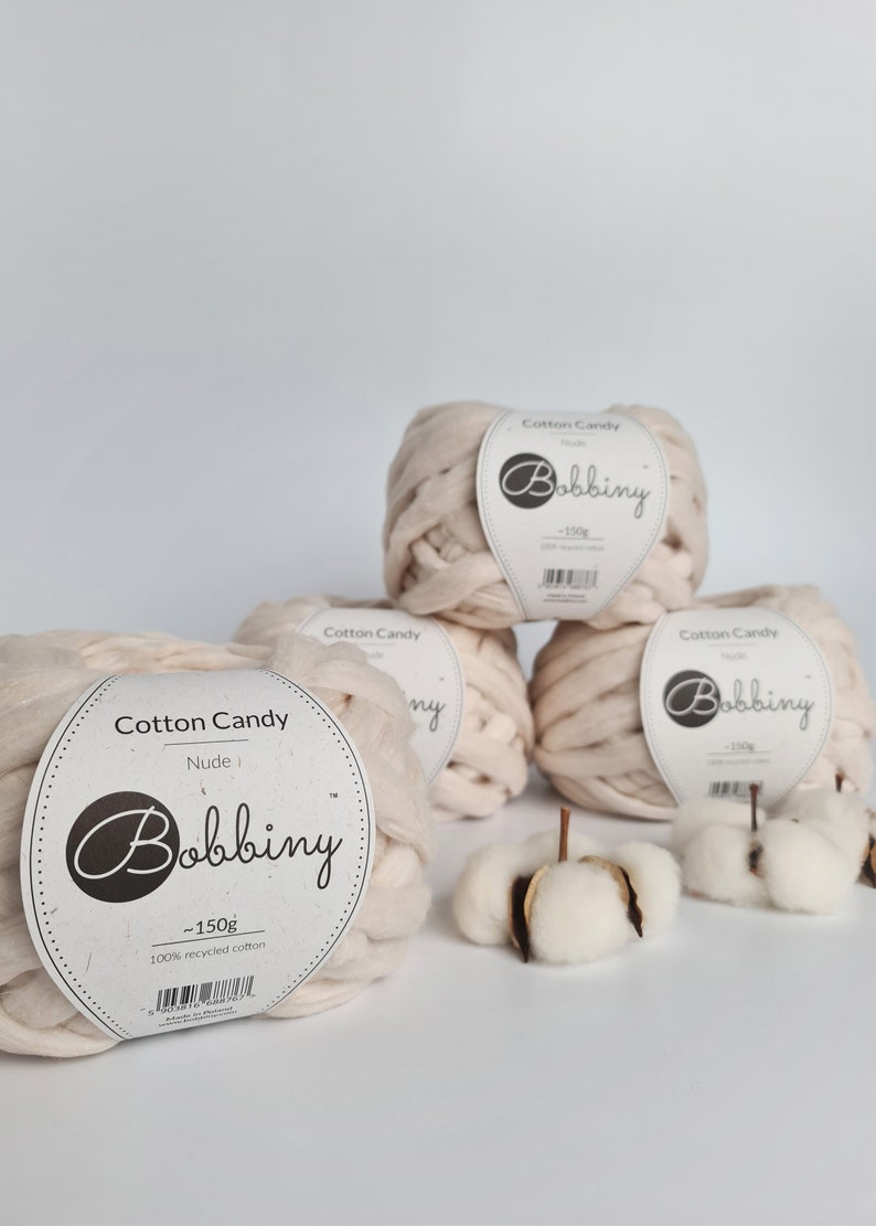 May include: Three balls of beige cotton candy yarn, each labeled "Cotton Candy" and "Bobbiny" with the weight of 150 grams. The yarn is 100% recycled cotton.