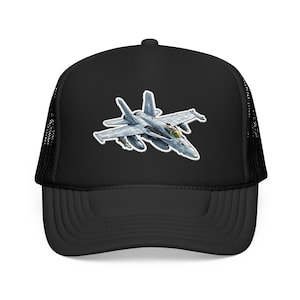 May include: Black trucker hat featuring a detailed illustration of a fighter jet. The jet is primarily gray with red and green accents. The hat has a curved brim and a mesh back for breathability.