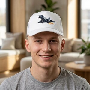 May include: White baseball cap featuring a detailed graphic of a jet aircraft with orange exhaust flames. The cap has a mesh back and a curved brim, offering a classic, sporty look.