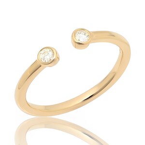 May include: A gold ring with two small round diamonds set into the band.