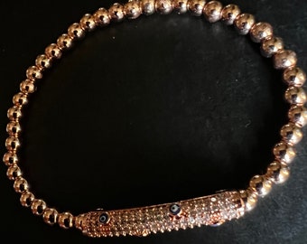 Bracelet boules rempli d'or rose : zircons cubiques et breloque mauvais œil