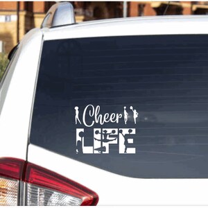Op de afbeelding: Witte vinyl auto sticker met de tekst "Cheer Life" en silhouetten van cheerleaders in verschillende poses.