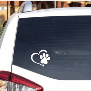 May include: White car window decal with a white paw print inside a heart shape.
