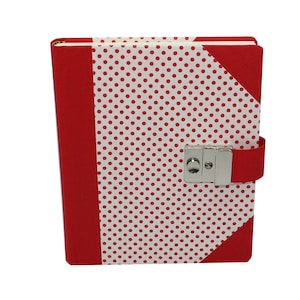Pode incluir: Diário vermelho com bolinhas brancas, com um cadeado prateado e uma alça vermelha.