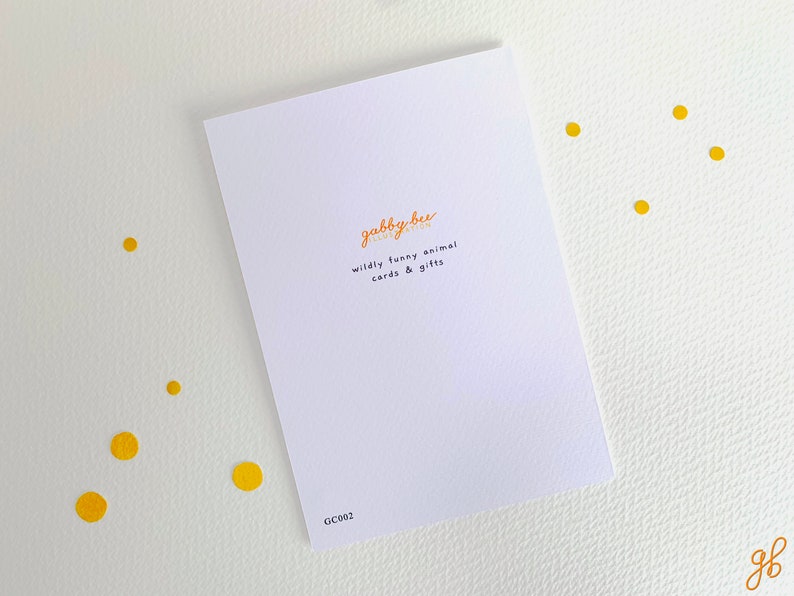 K&ouml;nnte beinhalten: Eine wei&szlig;e Karte mit dem Text "gabby bee" in Orange und Schwarz. Der Text "wildly funny animal cards & gifts" steht in Schwarz unter dem Logo. Die Karte hat den Code "GC002" in der rechten unteren Ecke.