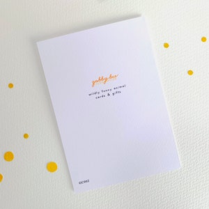 Może przedstawiać: Biała kartka z pozdrowieniami z pomarańczowym tekstem "gabby bee illustration" i "wildly funny animal cards & gifts". Karta leży na białej powierzchni z ż&oacute;łtymi kropkami. Widoczny jest kod "GC002".
