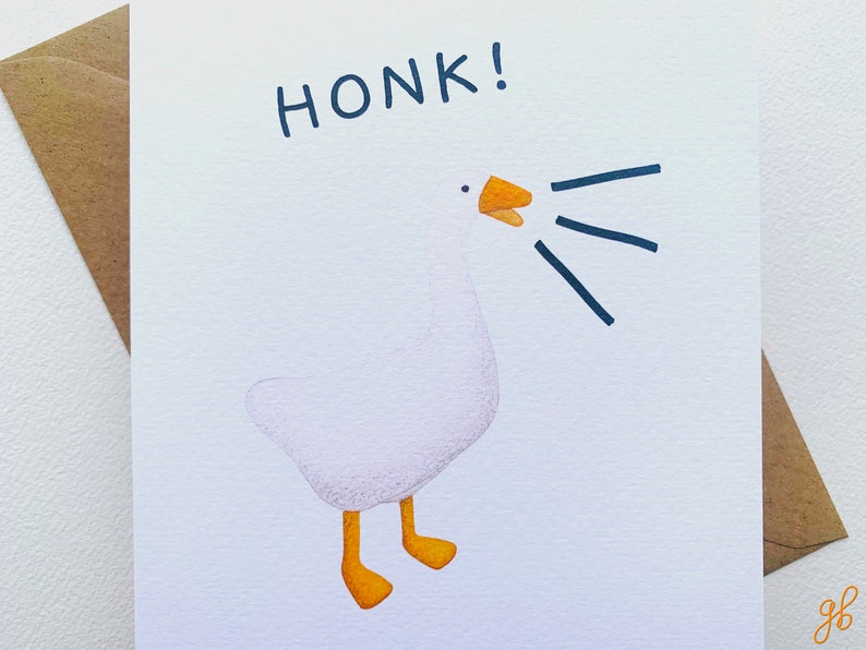 Może przedstawiać: Biała kartka z pozdrowieniami z akwarelową ilustracją gęsi. Gęś gęga, z napisem "HONK!" nad nią. Gęś ma pomarańczowe stopy i dzi&oacute;b. Brązowa koperta znajduje się po lewej stronie.