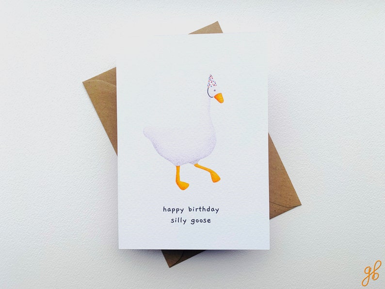 K&ouml;nnte beinhalten: Eine wei&szlig;e Gans mit einer Partym&uuml;tze mit roten und wei&szlig;en Punkten. Die Gans geht mit ausgestreckten F&uuml;&szlig;en. Der Text "happy birthday silly goose" ist unter der Gans gedruckt.