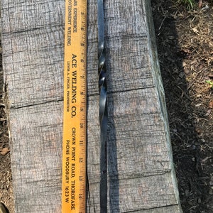 Może przedstawiać: Czarne metalowe narzędzie z zakręconym uchwytem i dwuzębnym końcem. Narzędzie ma 35,5 cm długości i jest mierzone przy użyciu drewnianej linijki z nadrukowanym tekstem "ACE WELDING CO. CROWN POINT ROAD, THOROFARE PHONE WOODBURY 1623 W".