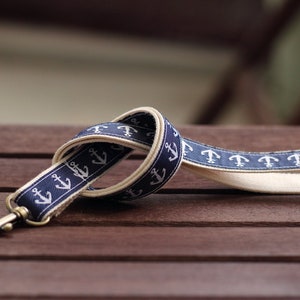Könnte beinhalten: Ein blaues und weißes Lanyard mit einem sich wiederholenden Ankermuster. Das Lanyard hat einen Metallverschluss.