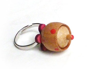 Ring of silver-colored metal with a red wooden flower and wooden sugar bowl with lid and red dots / polkadots