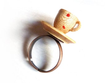 Ring made of copper-colored metal with a blank wooden cup & saucer with red dots / polkadots