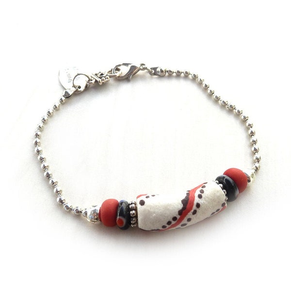 Sierlijke ball chain armband met een witte Afrikaanse handelskraal met rood en zwarte stippen, afgewerkt met een zilverkleurig karabijnslot