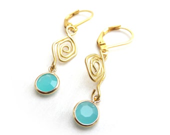 Gold-colored earrings with spiral ornament and a turquoise blue opaque colored facet pendant with an acrylic stone