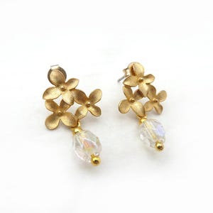 Elegante oorprikkers met goudkleurige bloemetjes en transparante facet geslepen glaskralen