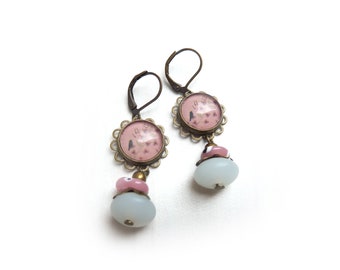 Brocante earrings with a glass cabochon, a black bird on a branch with flowers and musical notes on an old pink background