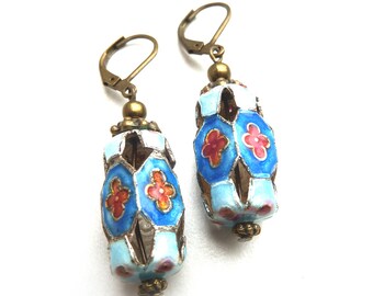 Boucles d'oreilles en métal de couleur bronze avec un ornement en émail dans des tons bleus avec une fleur rouge