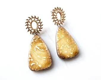 Gold-colored earrings with a glazed ceramic pendant