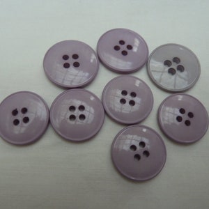 May include: Eight purple plastic buttons with four holes each.