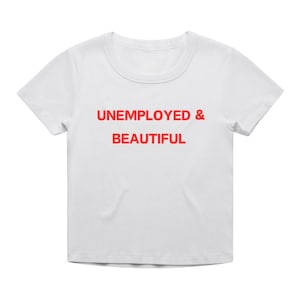 May include: White t-shirt with red text that reads "UNEMPLOYED & BEAUTIFUL".
