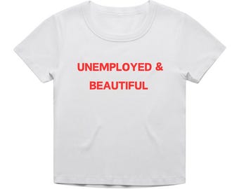 Könnte beinhalten: Weißes T-Shirt mit rotem Text, der "UNEMPLOYED & BEAUTIFUL" lautet.