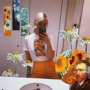 Pu&ograve; includere: Una maglietta bianca con una stampa di un dipinto di girasoli. La persona che indossa la maglietta &egrave; in piedi davanti a uno specchio con un design di girasole. Lo specchio &egrave; decorato con margherite e un'ape.