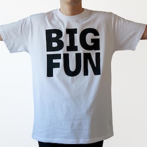 May include: White t-shirt with black text that reads "BIG FUN" in large, bold letters.