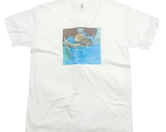 May include: A white t-shirt with a printed image of a monkey wearing a patterned shirt and lying in bed reading a book.