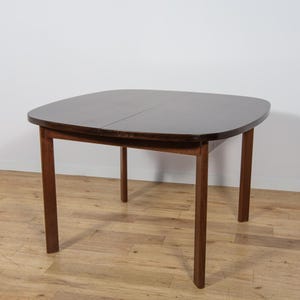 Peut inclure: Table de salle à manger de style moderne du milieu du siècle, de couleur marron foncé, avec un plateau carré arrondi et quatre pieds droits. La table mesure environ 76 cm de long, 76 cm de large et 74 cm de haut.
