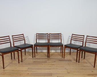 May include: Six mid-century modern dining chairs with dark wood frames and black leather seats.