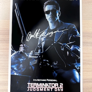 May include: A movie poster for Terminator 2: Judgment Day, featuring Arnold Schwarzenegger on a motorcycle. The poster has a dark background with the title and credits at the bottom. The text "It's Nothing Personal" is also visible.
