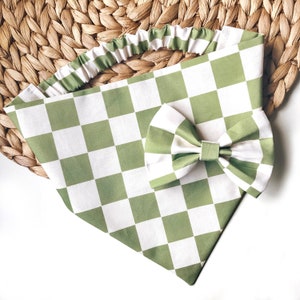 May include: A green and white checkered dog bandana with a matching bow tie. The bandana has a ruffled edge and is made of cotton.