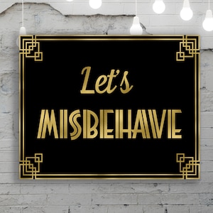 May include: A black sign with a gold frame and the text "Let's Misbehave" in gold lettering. The sign is hanging on a white brick wall with string lights hanging above it.